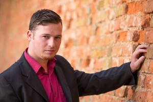 Abb. des Organisten Florian Neulinger vor einer Ziegelmauer