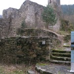 vier Stufen  umgeben von Steinmauern führen in das Innere der Ruiine des Burgkircherls