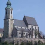 Abb. der Pfarrkirche St. Nikolaus in Emmersdorf an der Donau, der Turm im Vordergrund. Das aktuelle Logo des Nikolausboten.